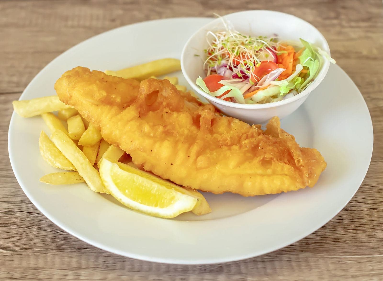 Battered fish, chips and salad on a plate